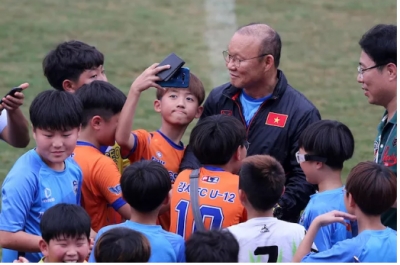 Học sinh H&agrave;n Quốc bao v&acirc;y HLV Park Hang-seo ngay tr&ecirc;n s&acirc;n Thống Nhất